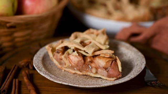 Slice of apple pie. Woman's hands serving plate with american apple pie slice on wooden table