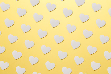 Fototapeta na wymiar Valentine's Day postcard. Valentine's Day Background. Trendy pattern made with paper hearts on bright light yellow background. Minimal style with colorful paper backdrop. Minimal creative concept