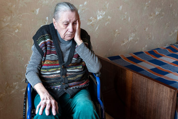 Disabled old woman in a wheelchair. Loneliness, old age, health problems, problems with memory.