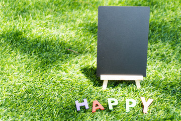 blank blackboard for copy space with English alphabet made of wood Meaning happy stand on the lawn in the garden