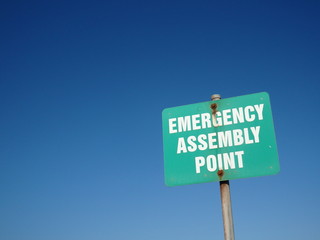 Enamel sign of emergency assembly point in green