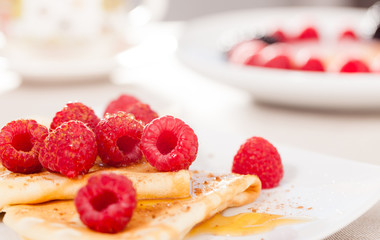 breakfast of pancakes with fresh raspberries on table