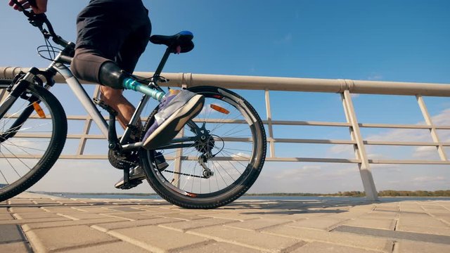 Athlete with a prosthetic leg is getting on a bike