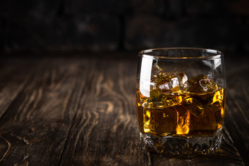 Whiskey in the glasses on dark background.