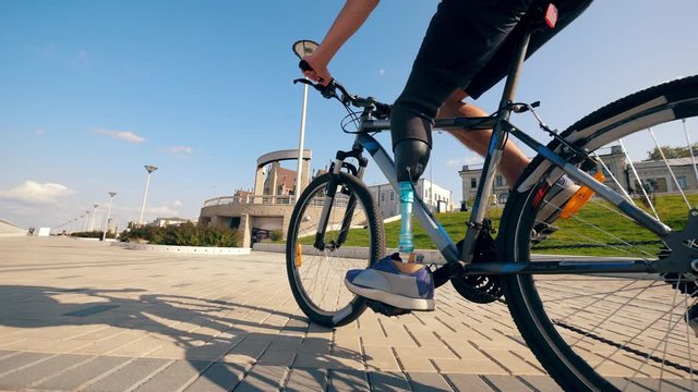 A bike is being ridden by a person with a prosthetic leg