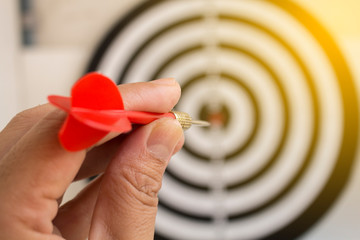 Hand Holding dart throwing to dartboard for final score target business concept