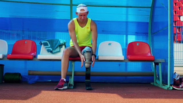 Removal of a prosthetic leg done by a male paralympian