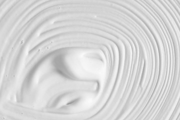White cosmetic foam texture background. Cosmetic mousse, cleanser, shaving foam, shampoo. Foamy skin care product swirl