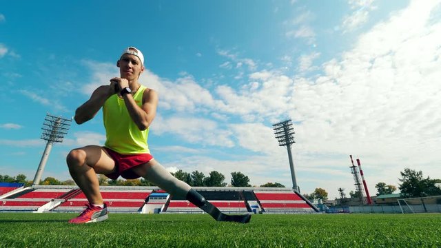 Stadium and an athlete with a prosthetic leg working out on it