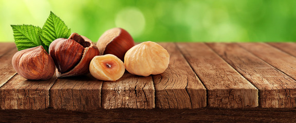 Nuts on wooden table and nature in background