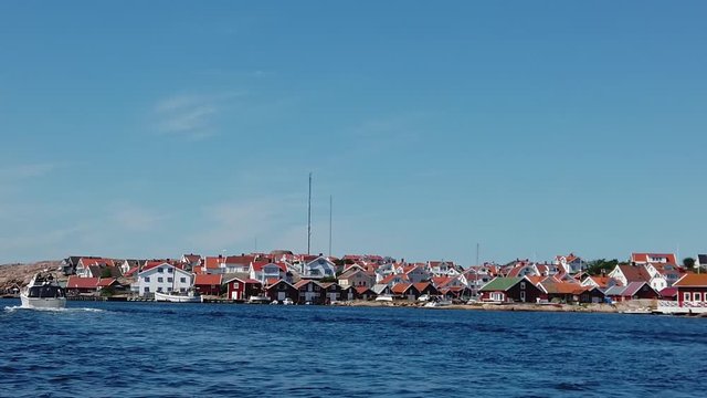 Red and white wooden boathouses in the port of Kungshamn, a small fishing village on the west coast of Sweden