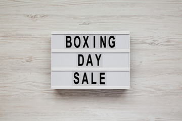 'Boxing day sale' words on a modern board on a white wooden background, top view. Overhead, from above, flat lay.