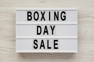 'Boxing day sale' words on a modern board on a white wooden surface, top view. Overhead, from above, flat lay.