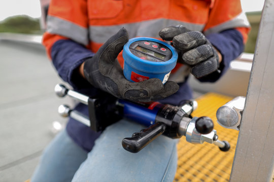  Engineer Inspecting Pull Testing Machinery Measurement Device Prior To Testing Chemical Anchor Abseiling Fall Arrest Fall Restraint Anchor Point Construction Site, Sydney CBD, Australia