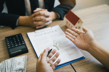 Obraz premium Customers buying houses are negotiating about the cost of home insurance with agents.