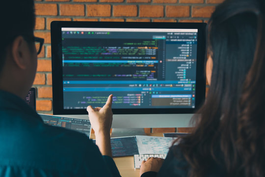 Developing programming and coding technologies working in a software engineers developing applications together in office.