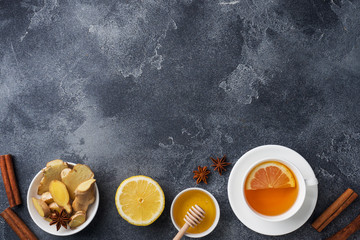 Fototapeta na wymiar White Cup with natural herbal tea ginger lemon and honey cinnamon. Energy vitamin drink is used for colds.Dark concrete background copy space