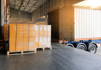 Packaging Boxes Wrapped Plastic Film on Pallet Loading into Shipping Cargo Container. Supply Chain. Trucks Parked Loading at Dock Warehouse. Shipment Logistics. Cargo Freight Truck Transport.	