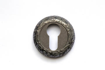 old round metal keyhole lies on a table