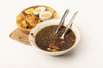 indonesian dishes rawon and eggs on white background isolated.