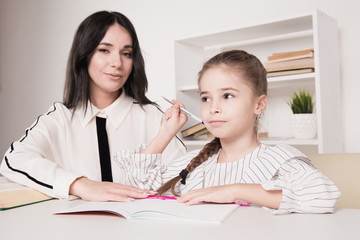 Happy mother and daughter studying together at home