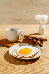 Breakfast is on the table. A cup of tea. Fried egg and toast bread