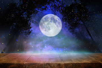 Holidays Halloween concept. Empty rustic table in front of scary and misty night sky and full moon...