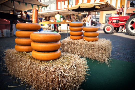 Holland cheese rounds displayed on hay stack at traditional market