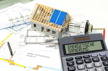 Fototapeta na wymiar Construction or building plan with bricks and calculator showing the german word for energetic renovation - energetische sanierung