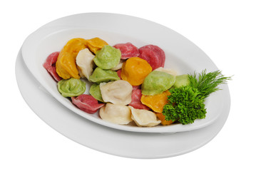 Multi-colored ravioli, dumplings with parsley and dill on a white isolated background