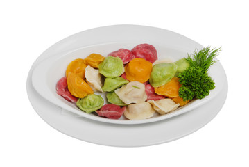 Multi-colored ravioli, dumplings with parsley and dill on a white isolated background