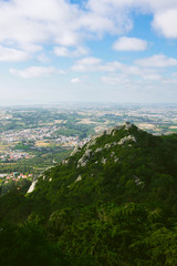 Cloudy view on the hill and portuguese town with green landscape