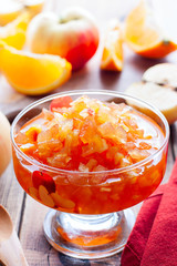 Fruit jam from apples and oranges in a glass vase, selective focus