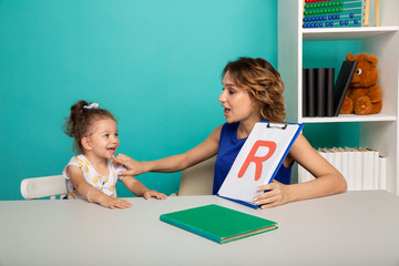 Speech therapy concept. Kid with therapist learning letters together