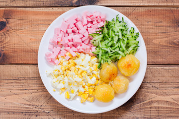 Step-by-step preparation of traditional Russian cold okroshka soup, step 1 - slicing ingredients, top view, horizontal