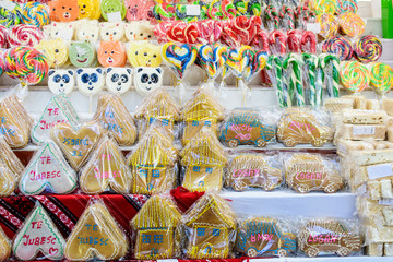 Group of vivid coloured sugar lollipops in display for sale at a candy store in individual plastic packaging, selective focus