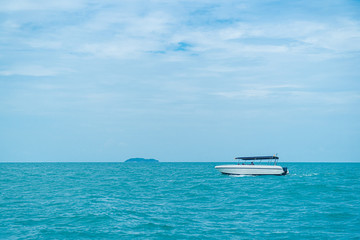 Fototapeta na wymiar speed boat driving on ocean with cloudy sky