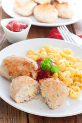 Homemade turkey cutlets with cheese filling on a white plate, selective focus