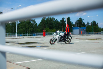 A biker girl with her motorcycle on the racetrack