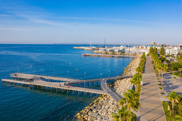 Fototapeta na wymiar Limassol from above. Panorama Of Cyprus. The seaside promenade of Molos. A pedestrian pier leads to the sea. The water of the Mediterranean sea is blue. Walking along the promenade of Limassol.