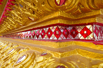 Thailand. Phuket Island. Fragment of the decoration of a Buddhist temple. Decoration of temples in Thailand. Architecture Of Thailand. Carvings and glass mosaics adorn the Buddhist temple.