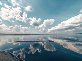 Fototapeta na wymiar Amazing landscape of the sea with reflection in the water the white clouds.