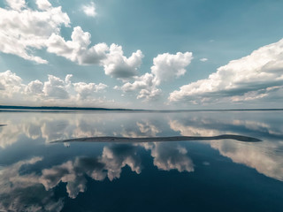 Amazing landscape of the sea with reflection in the water the white clouds.