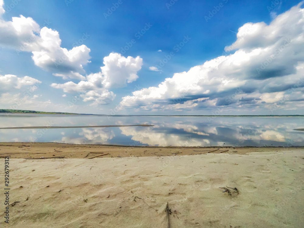 Wall mural Amazing landscape of the sea with reflection in the water the white clouds.