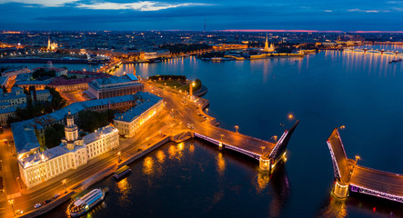 Fototapeta premium Panorama of evening Saint Petersburg from a height. Bridges Of St. Petersburg. Rivers Of St. Petersburg. Palace bridge across the Neva divorced. Vasilievsky island in the evening lights.