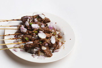 chicken satay with peanut sauce on dish isolated white background