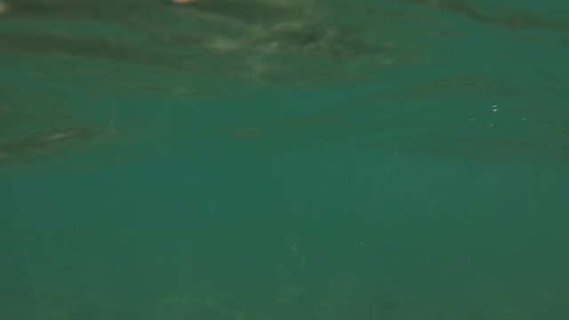 Slow motion surface sea water waves with tourists swimming