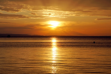 Fototapeta na wymiar Evening in September. Sunset. Ship silhouette on the horizon. Beautiful view . Greece Sithonia Aegean Sea. Skyline. Horizon. Sky clouds. The setting sun