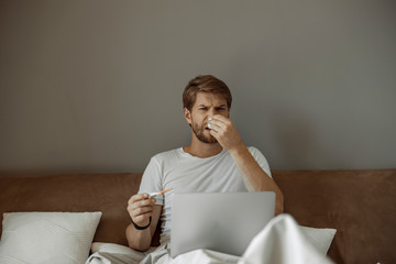 Sick man being unpleased with his body temperature