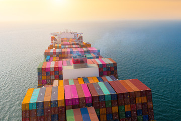 top aerial view of the large volume of TEU containers on ship sailing in the sea carriage the shipment from loading port to destination,  heading to the destination of success light